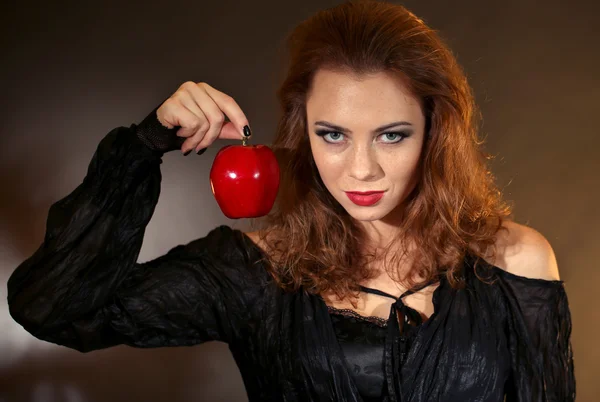Strega di Halloween con mela su sfondo scuro — Foto Stock