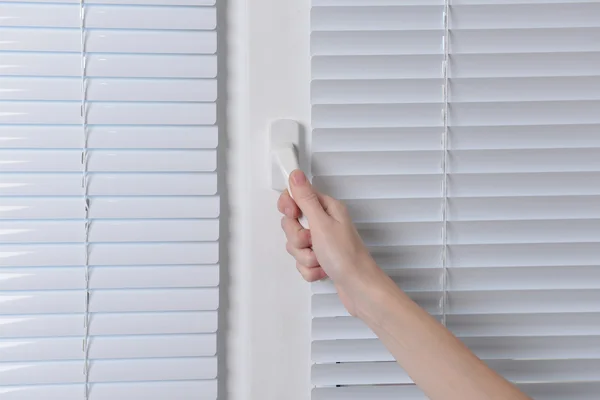 Hand öppningsbart fönster med vita persienner, närbild — Stockfoto