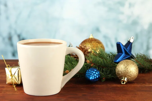Tasse heißen Kakao mit Weihnachtsdekoration auf Tisch auf hellem Hintergrund — Stockfoto