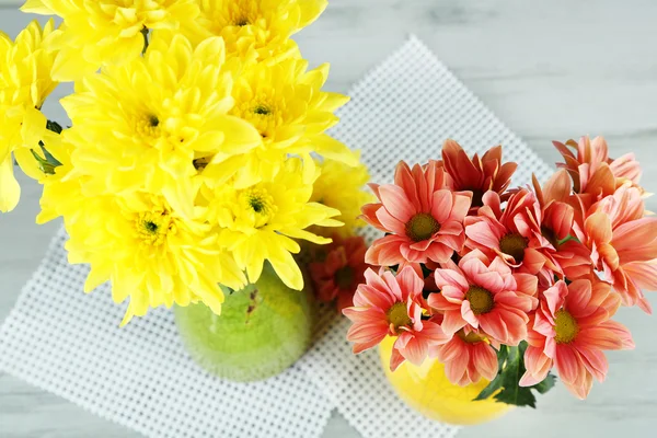 Красивые цветы в вазах, на фоне деревянного стола — стоковое фото