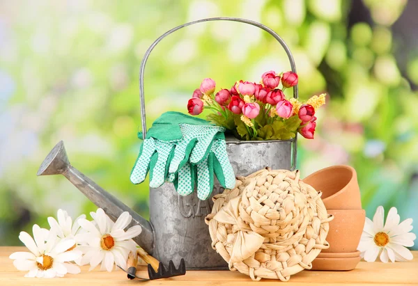 Herramientas de jardinería y flores sobre mesa de madera, al aire libre — Foto de Stock