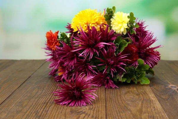 明るい背景上の木製のテーブルの上の美しい花 — ストック写真