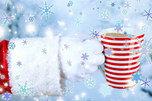 Santa segurando caneca em sua mão, no fundo claro — Fotografia de Stock