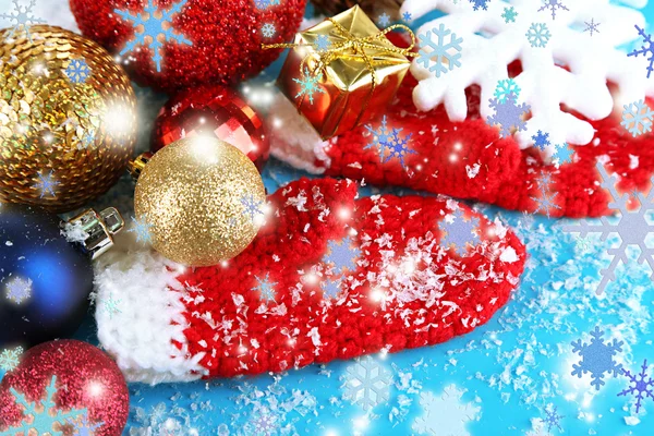 Red winter mittens with Christmas toys on blue wooden table — Stock Photo, Image