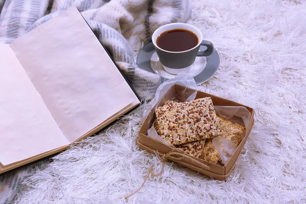 Composition with warm plaid, book, cup of hot drink on color carpet background — Stock Photo, Image