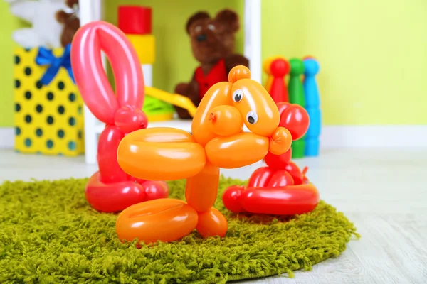 Simple balloon animals and other toys on shelves, on bright background — Stock Photo, Image