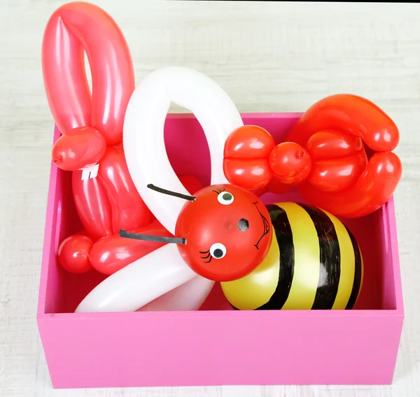 Simple balloon animals in wooden box,on gray background — Stock Photo, Image