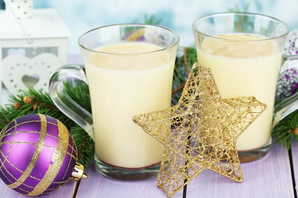 Cups of eggnog with fir branches and Christmas decorations on table close up — Stock Photo, Image