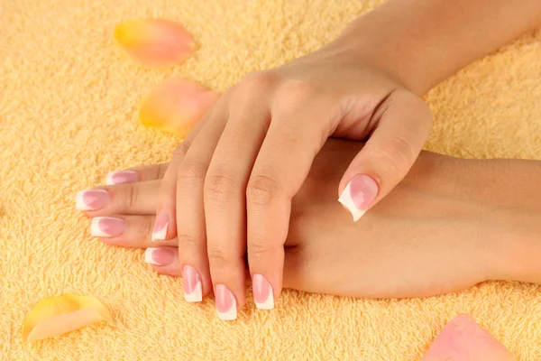 Woman's hands on yellow terry towel, close-up — Stock Photo, Image