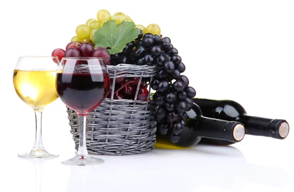 Flessen en glazen wijn en druiven in mand, geïsoleerd op wit — Stockfoto