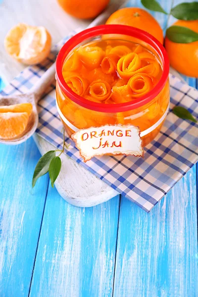 Sinaasappeljam met schil en mandarijnen, op blauwe houten tafel — Stockfoto