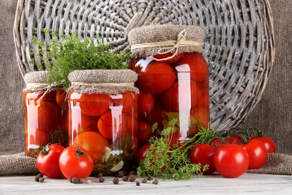 Sabrosos tomates enlatados y frescos sobre mesa de madera —  Fotos de Stock