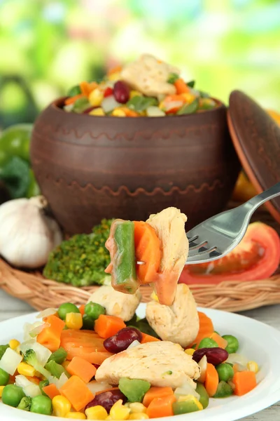 Gebakken gemengde groenten met kipfilet in pot, op lichte achtergrond — Stockfoto