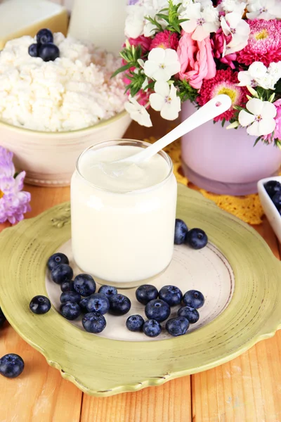 Frische Milchprodukte mit Blaubeeren auf Holztisch in Großaufnahme — Stockfoto