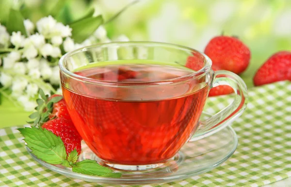 Delicious strawberry tea on table on bright background — Stock Photo, Image