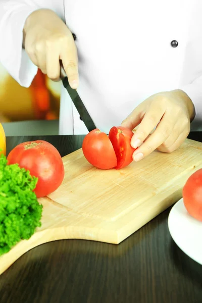 Mãos de cozinheiro corte de tomate — Fotografia de Stock