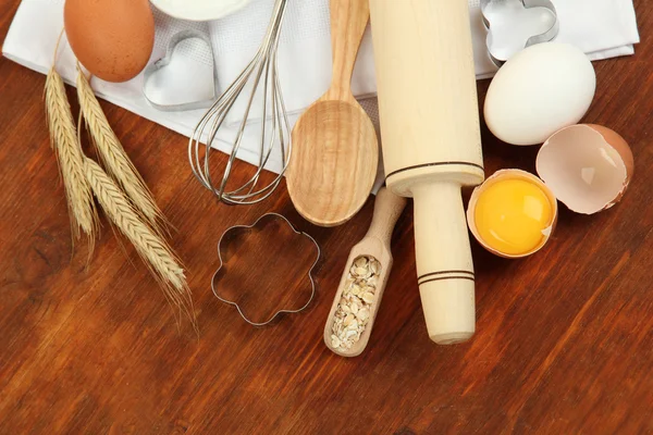 Conceito de cozinha. Ingredientes básicos de cozimento e utensílios de cozinha na mesa de madeira — Fotografia de Stock