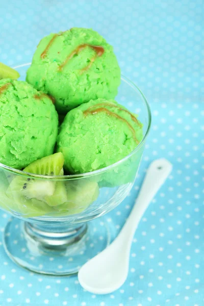 Delicious ice cream on glass vase on blue tablecloth — Stock Photo, Image