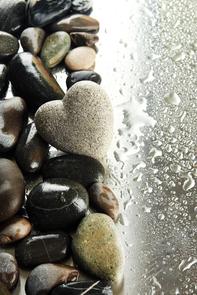 Grey stone in shape of heart, on light background — Stock Photo, Image