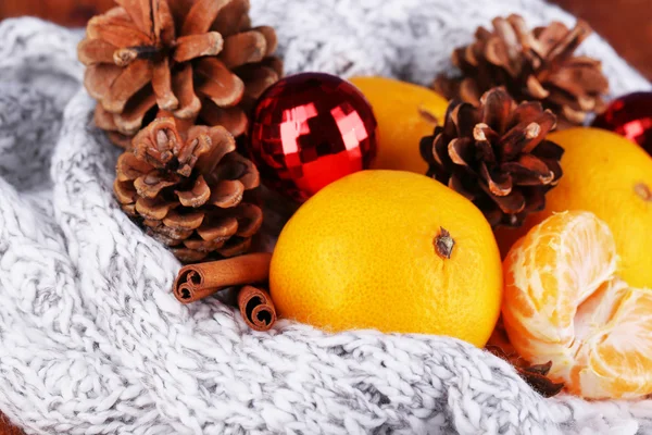 Mandarinen und Weihnachtsspielzeug auf Strickschal in Nahaufnahme — Stockfoto