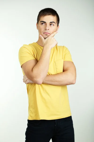 Portrait of young man on grey background — Stock Photo, Image