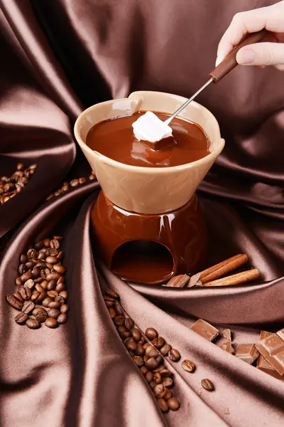 Chocolate fondue with marshmallow candies, on brown background — Stock Photo, Image