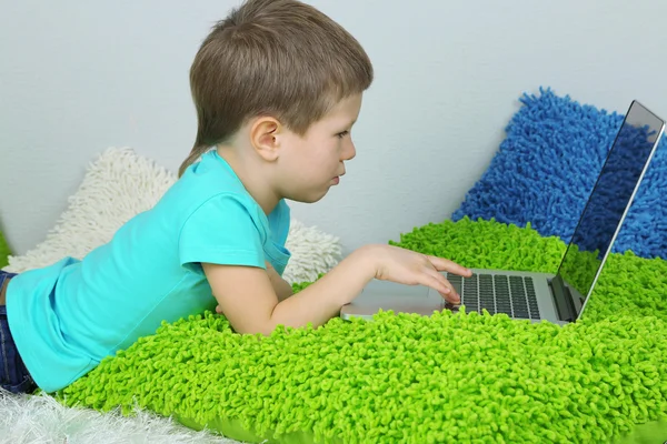 Kleine jongen met laptop op bed — Stockfoto