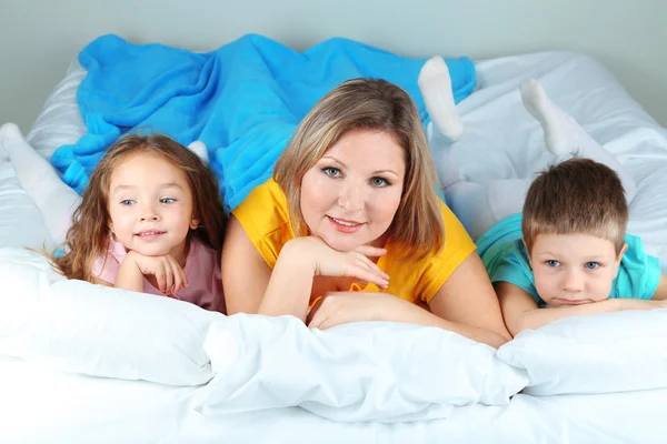 Little children with mom lying in bed — Stock Photo, Image