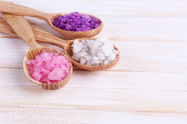 Wooden spoons with sea salt, on color wooden background — Stock Photo, Image