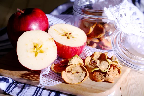 Gedroogde appels in glazen pot, op een houten achtergrond kleur — Stockfoto