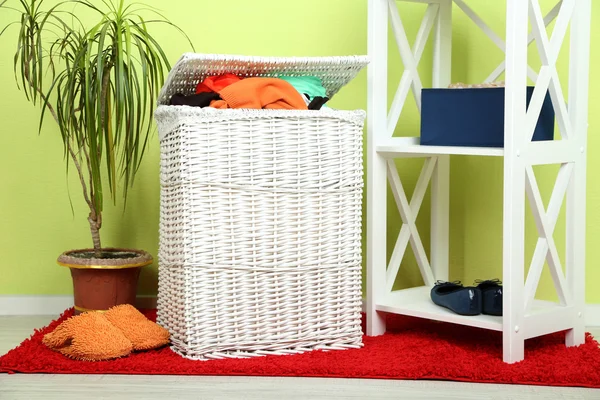 Full laundry basket on wooden floor on home interior background — Stock Photo, Image