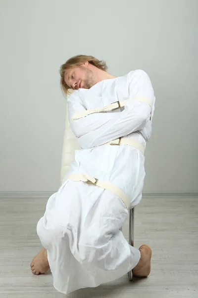 Mentally ill man in strait-jacket on gray background — Stock Photo, Image