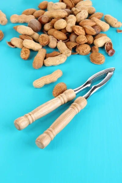 Louskáček s ořechy na dřevěný stůl detail — Stock fotografie