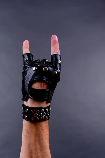 Hand der Rocker in Lederarmband und Fäustling, auf grauem Hintergrund — Stockfoto