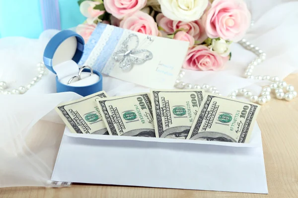 Dollar bills in envelope as gift at wedding on wooden table close-up — Stock Photo, Image