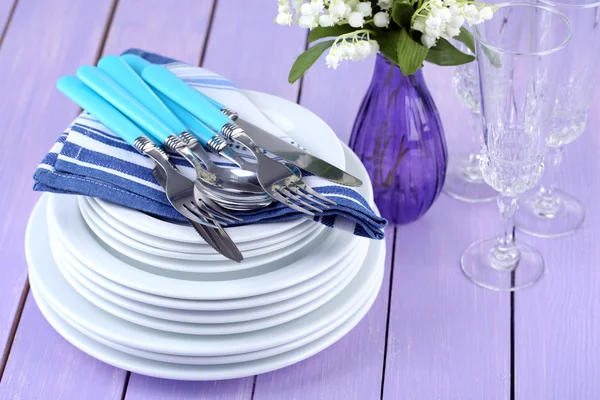 Clean dishes on wooden table on color background — Stock Photo, Image