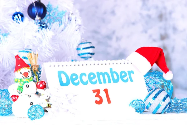 Календарь с новогодними украшениями на зимнем фоне — стоковое фото