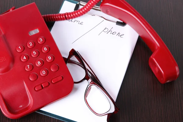 Telefono e blocco note e altri oggetti, su sfondo di legno — Foto Stock