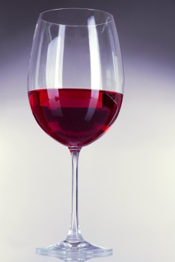 Gri arka planda bir kadeh şarap.