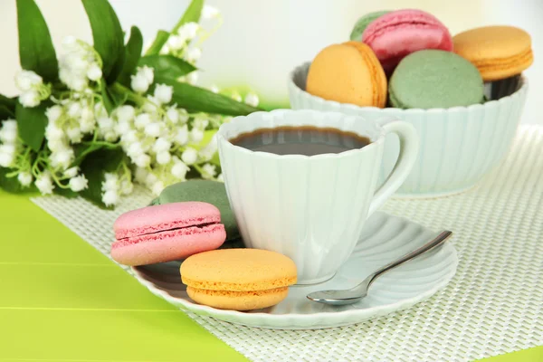 Café et macarons sur table sur fond clair — Photo