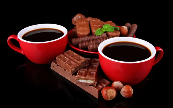Tazze rosse di caffè forte e barrette di cioccolato isolate su nero — Foto Stock
