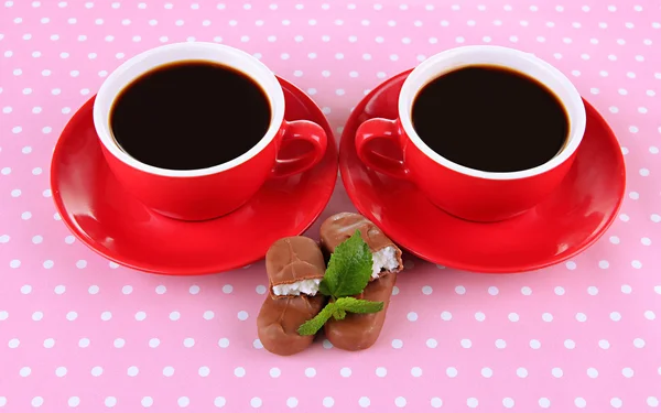 Tasses rouges de café fort et de barres de chocolat sur fond à pois — Photo