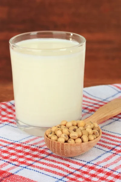Soy beans with glass of milk on table on wooden background — Stock Photo, Image