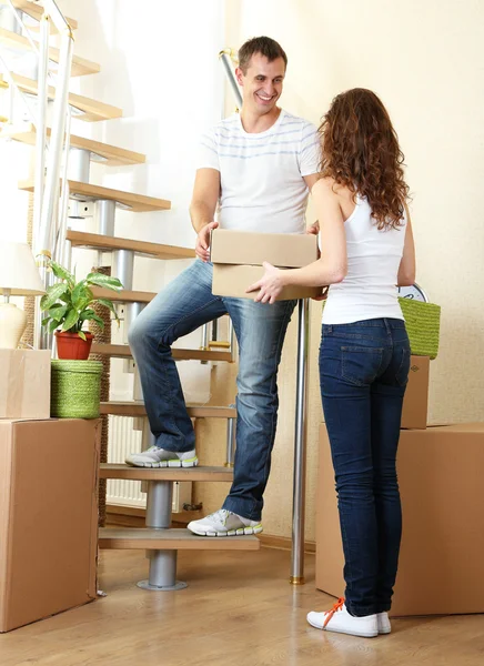 Pareja joven con cajas en casa nueva en la escalera —  Fotos de Stock