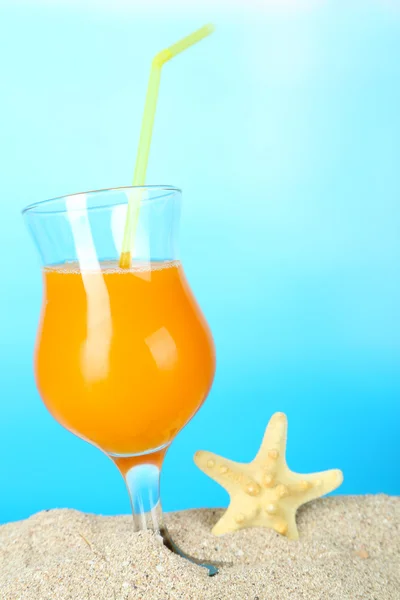 Пляжний коктейль у піску на синьому фоні — стокове фото