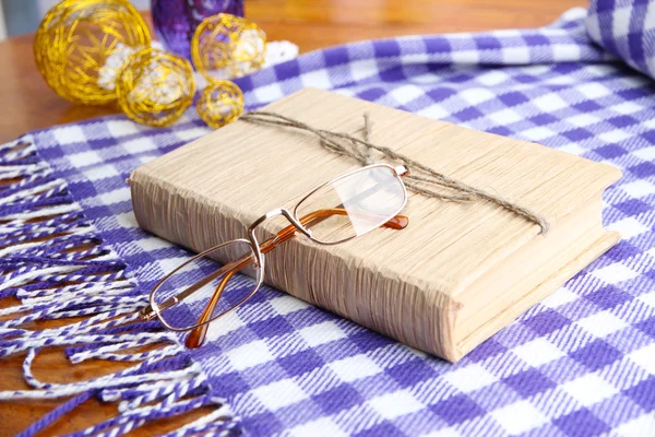 Composition with old book, eye glasses, and plaid on wooden background — Stock Photo, Image