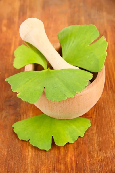 Ginkgo biloba φύλλα σε γουδί και χάπια σε ξύλινα φόντο — Φωτογραφία Αρχείου