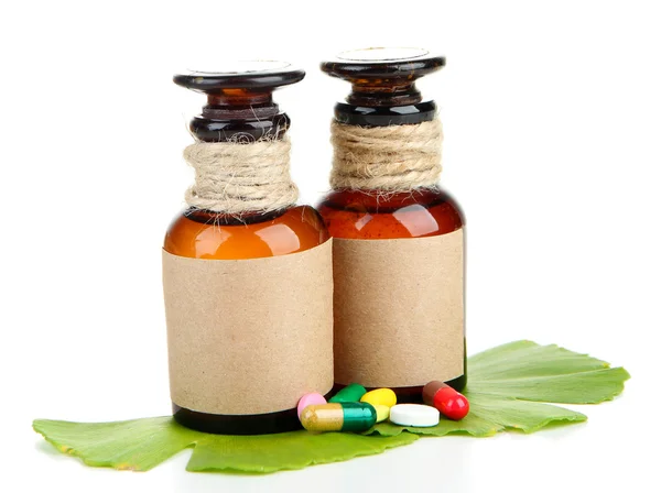 Ginkgo biloba leaves and medicine bottles with pills isolated on white — Stock Photo, Image