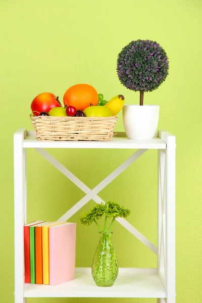 Composition of various home furnishing on white shelf on green wall background — Stock Photo, Image