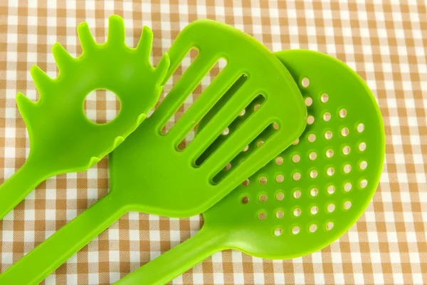 Plastic kitchen utensils on fabric background — Stock Photo, Image